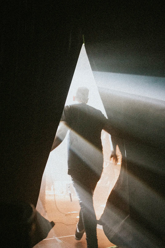 musician walking onto the stage curtain